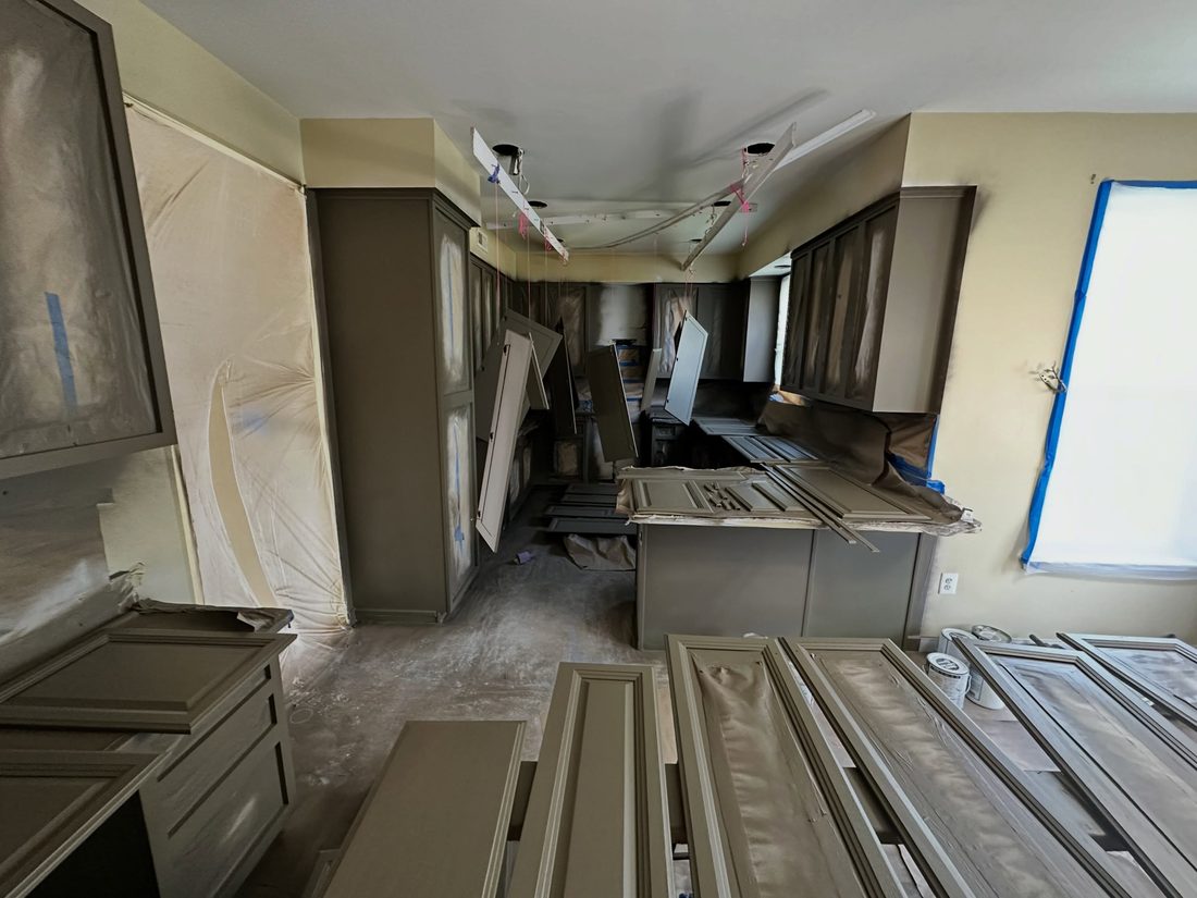 Cabinet doors off and masked, mid-spray